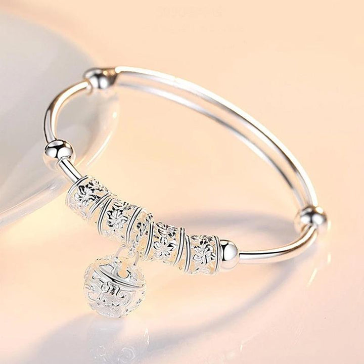 "Silvrigt justerbart armband för kvinnor med pärldetaljer, elegant blommönster, perfekt accessoar för alla smyckessamlingar."