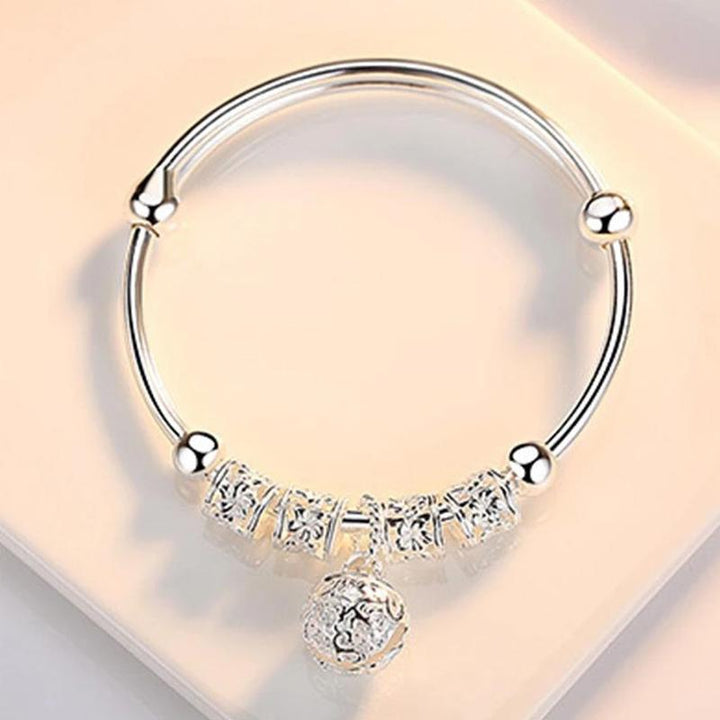 "Silvrigt justerbart armband för kvinnor med pärldetaljer, elegant blommönster, perfekt accessoar för alla smyckessamlingar."