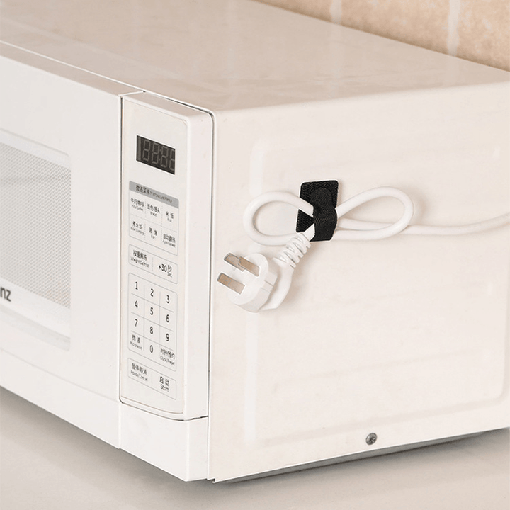 "Självhäftande kardborrearrangör för kablar, svart nylon, justerbar 28x90 mm, enkel installation på plana ytor."