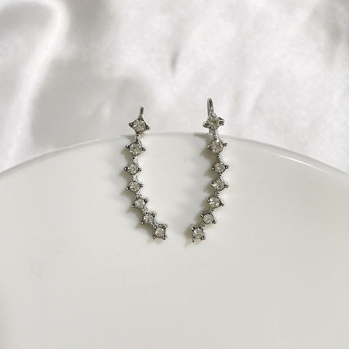 "Sju-stjärniga stiftörhängen med kristaller i guld, eleganta accessoarer för kvinnor, glänsande och sofistikerad design."