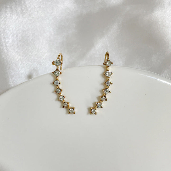 "Sju-stjärniga stiftörhängen med kristaller i guld, eleganta accessoarer för kvinnor, glänsande och sofistikerad design."