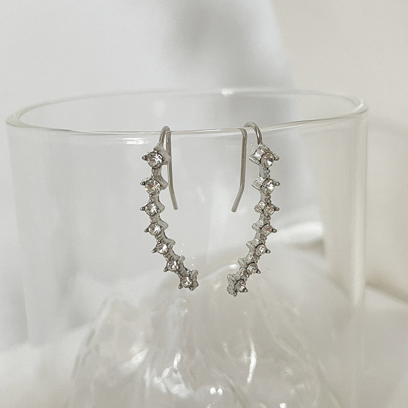 "Sju-stjärniga stiftörhängen med kristaller i guld, eleganta accessoarer för kvinnor, glänsande och sofistikerad design."