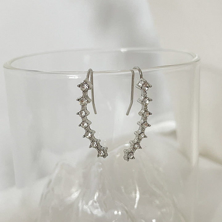 "Sju-stjärniga stiftörhängen med kristaller i guld, eleganta accessoarer för kvinnor, glänsande och sofistikerad design."