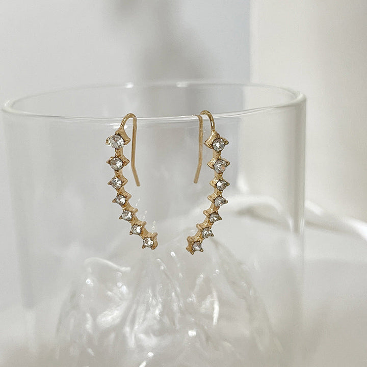 "Sju-stjärniga stiftörhängen med kristaller i guld, eleganta accessoarer för kvinnor, glänsande och sofistikerad design."