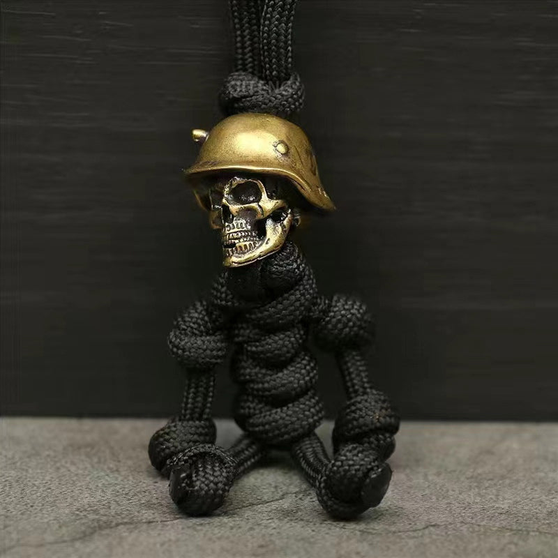"Skelet soldat nyckelring i koppar och paracord, robust design med slitstark tygfläta och unik kopparlook."