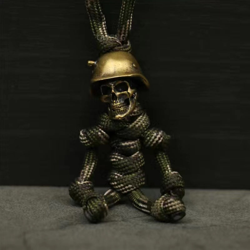 "Skelet soldat nyckelring i koppar och paracord, robust design med slitstark tygfläta och unik kopparlook."