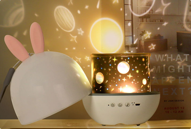 "SkyProjector stjärnprojektor nattlampa med stjärnor, månar och figurer; blå, vit, gul atmosfär, barnrum dekoration"