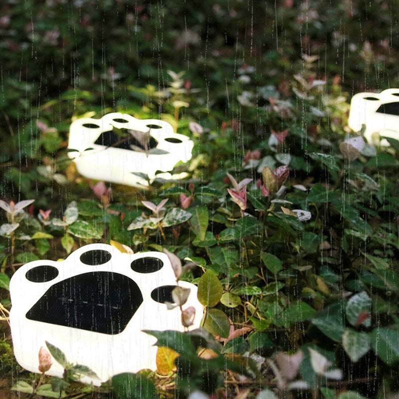 "Smart solcellslampa med björntassmönster, ger naturligt ljus utomhus, tålig design, justerbart varmt och vitt ljus."