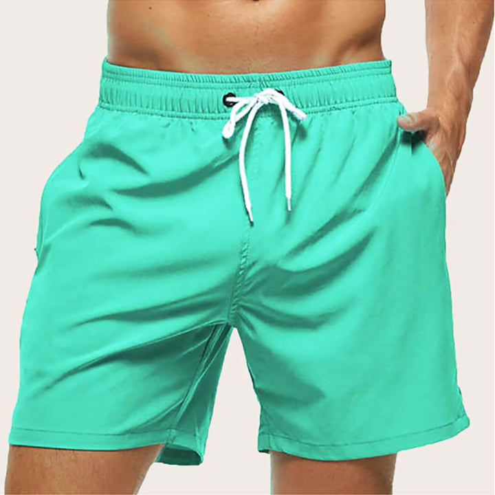 "Snabbtorkande badshorts i grått med ljusblå detaljer, elastisk midja och trendig design för män på sommaren."
