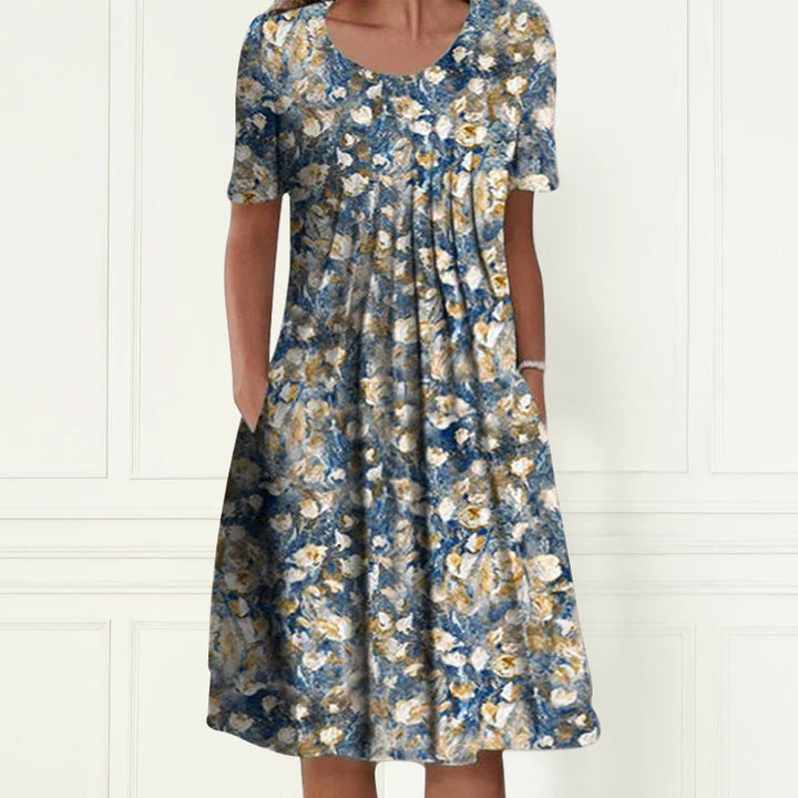 "Somrig blommig damklänning med korta ärmar, rund hals och feminin look, perfekt för avslappnade sommaräventyr."