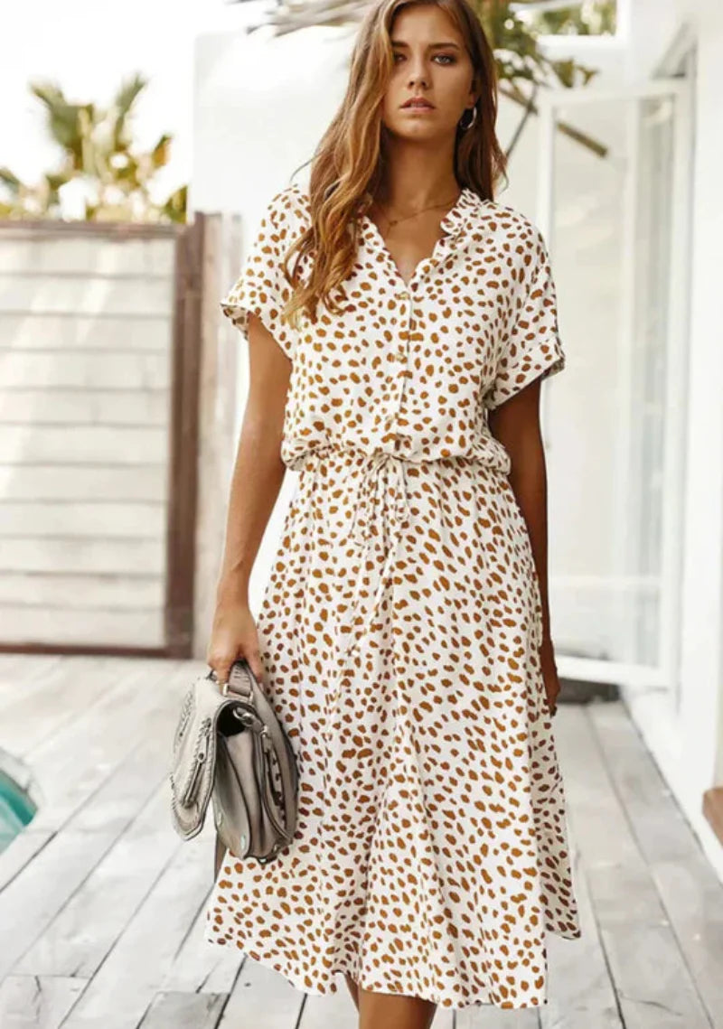 "Somrig vintageklänning med mittärmar och flytande silhuett, perfekt för sommar, visas på modell med elegant look."