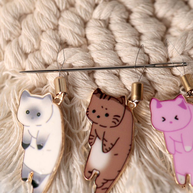 "Söt katt nålgängare i olika färger för enkel nålträdning, funktionell och stilfull accessoar för broderi."