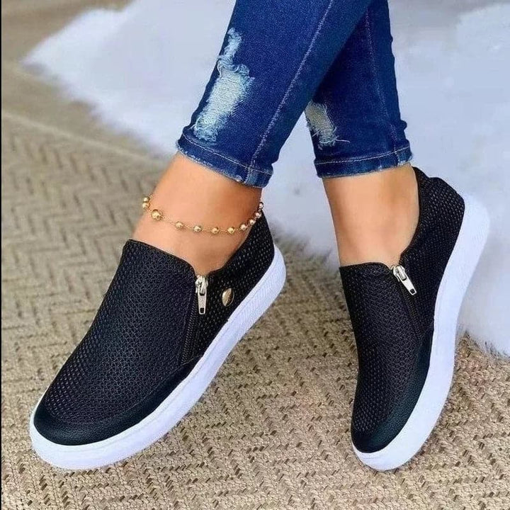 "Svarta mesh zip-up sneakers med vita flexibla sulor och sidodragkedja för enkel påtagning, perfekt kombination av stil och k