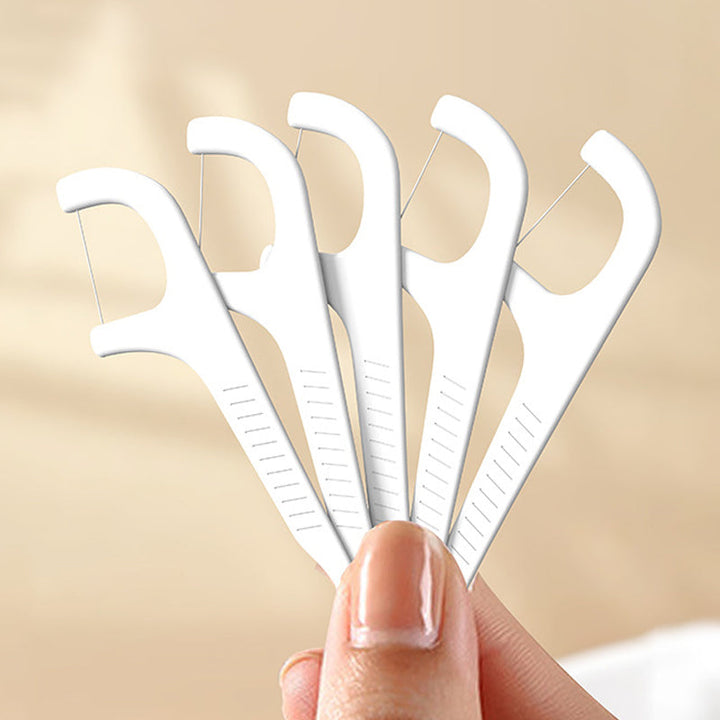 "Tandtrådsdispenser för resor i grön, rosa, vit. Bärbar och kompakt accessoar för enkel användning och påfyllning."