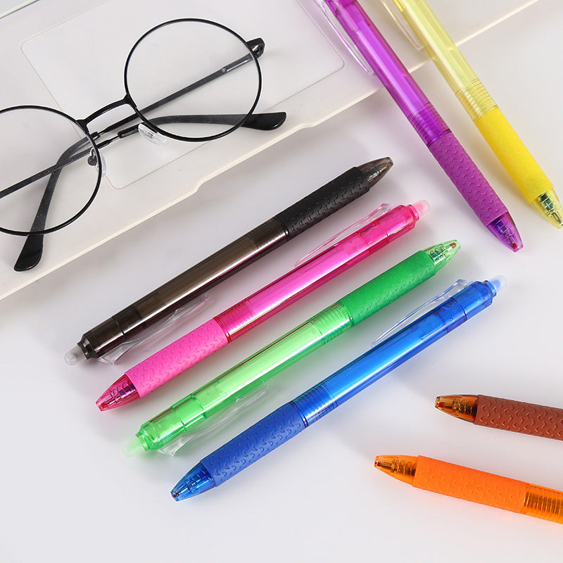 "Top down view of colorful erasable gel pens on white background with visible pen tips and vibrant colors."