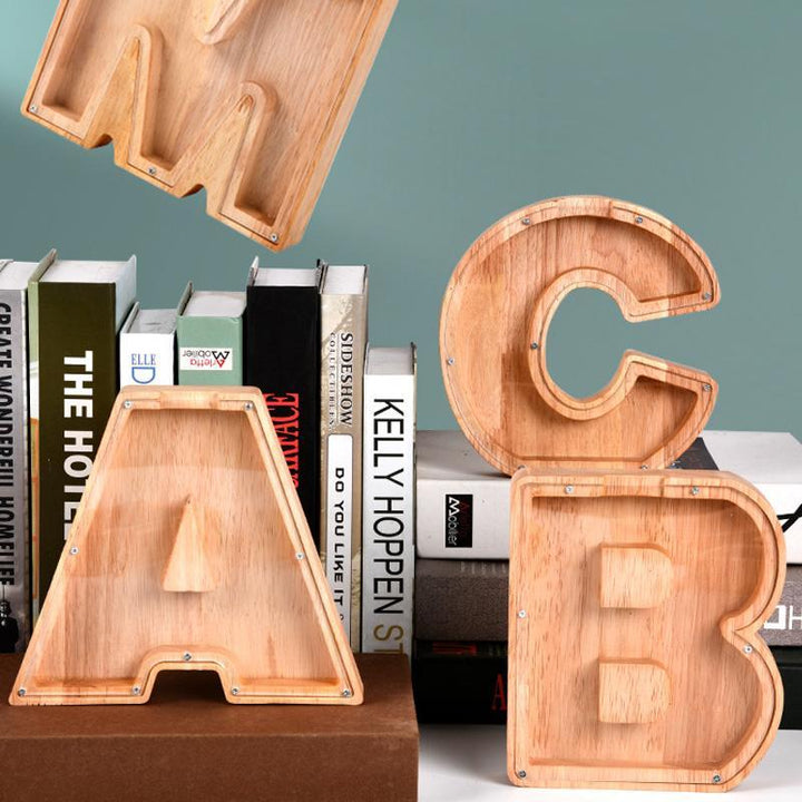 "Unisex trä spargris med bokstavsdesign i ek, miljövänlig och barnsäker, inkluderar alfabetklistermärken för personlig stil."