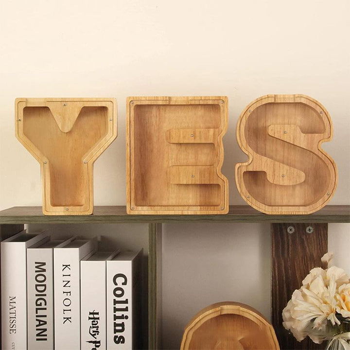 "Unisex trä spargris med bokstavsdesign i ek, miljövänlig och barnsäker, inkluderar alfabetklistermärken för personlig stil."