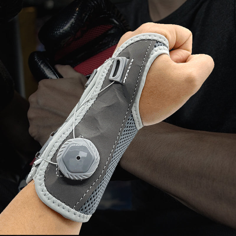 "Unisex vrist stödbandage i grå och svart för sport och träning, med justerbar passform och mikrofibertyg för stöd."