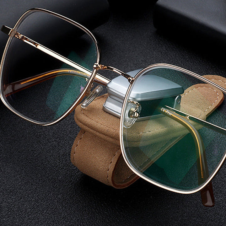 "Universell solglasögonklämma på bilvisir, robust aluminium och läder, skyddar glasögon, kompakt och lätt att installera."