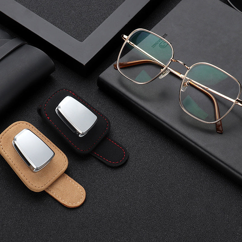 "Universell solglasögonklämma på bilvisir, robust aluminium och läder, skyddar glasögon, kompakt och lätt att installera."