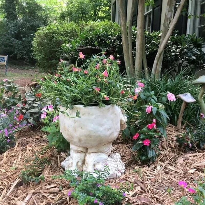 "Uttrycksfull ansiktskruka i harts med handmålad finish, idealisk för unik trädgårdsdekoration och dekoration inomhus."