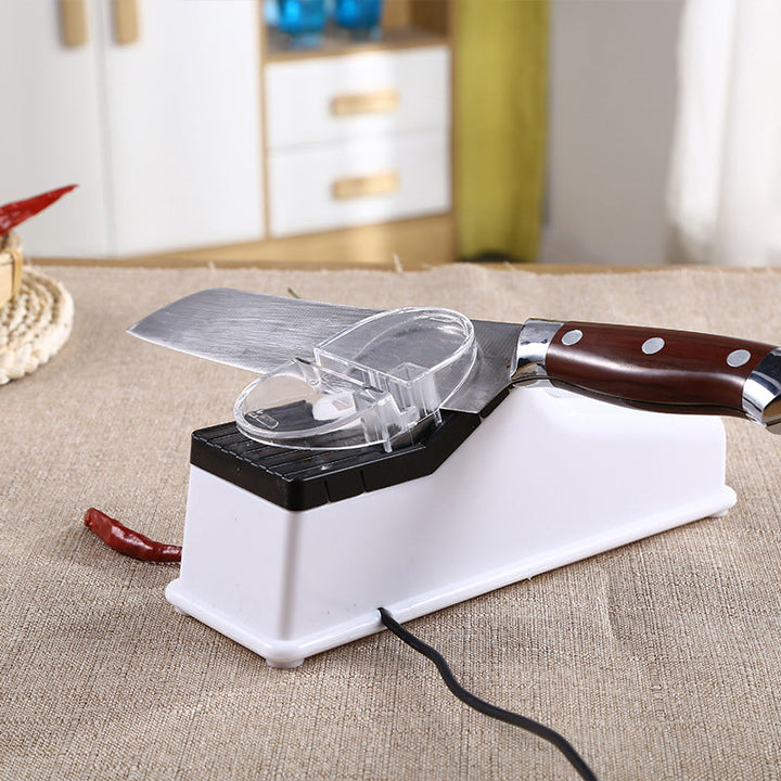 "Vit elektrisk köksknivslipare, kompakt design med USB-laddning och halkfri bas för snabb och säker slipning."